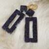 Boucles d'oreilles (fermoirs dormeuse plaqué or 24k) en résine noire avec insert de paillettes holographiques composée d'un petit carré et d'un rectangle plus long
