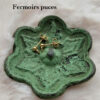 Fermoirs "puces" posés sur une coupelle en métal verte en forme de fleur