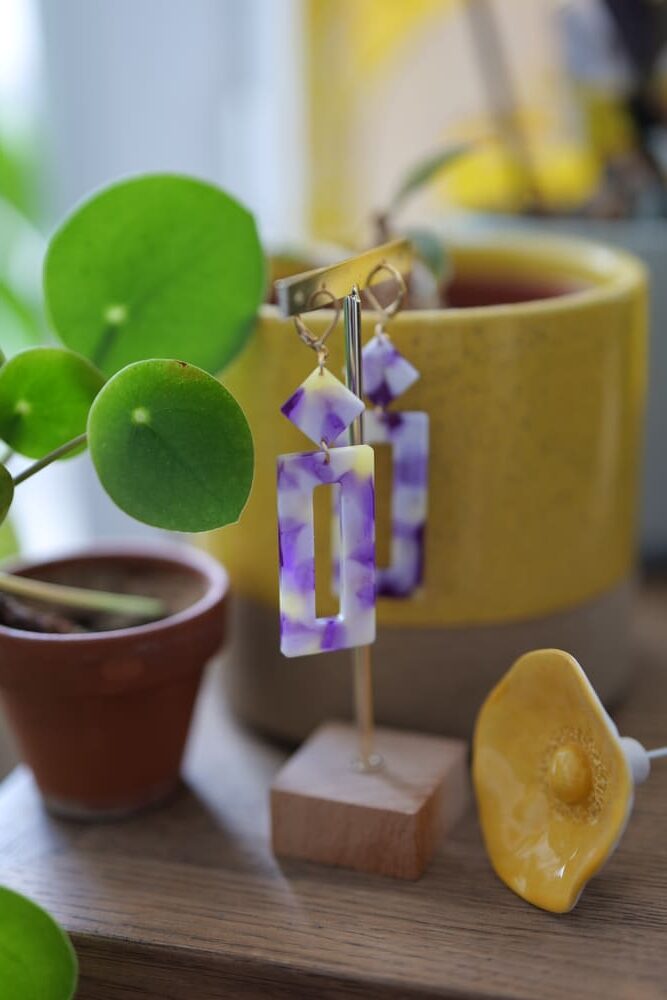 Boucles d'oreilles (fermoirs dormeuse plaqué or 24k) en résine colorée (violet, jaune, blanc) composée d'un petit carré et d'un rectangle plus long.