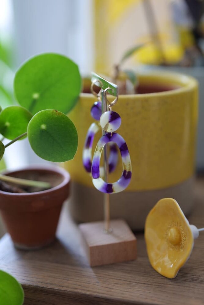Boucles d'oreilles (fermoirs dormeuse plaqué or 24k) en résine colorée (violet, jaune, blanc) composée d'un petit rond et d'un ovale asymétrique plus grand.