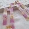 Boucles d'oreilles (fermoirs dormeuses plaqué or 24k) en résine (rose, blanc et inclusion de feuilles d'or) d'un petit carré et d'un rectangle plus long.