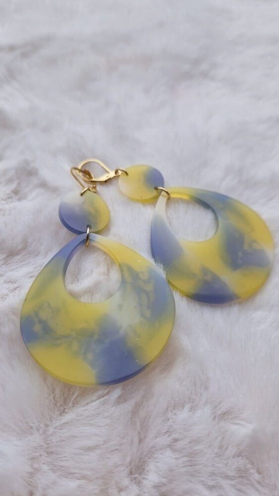 Boucles d'oreilles (fermoirs dormeuse plaqué or 24k) en résine colorée (mauve, jaune, blanc) composée d'un petit rond et d'un ovale plus large.